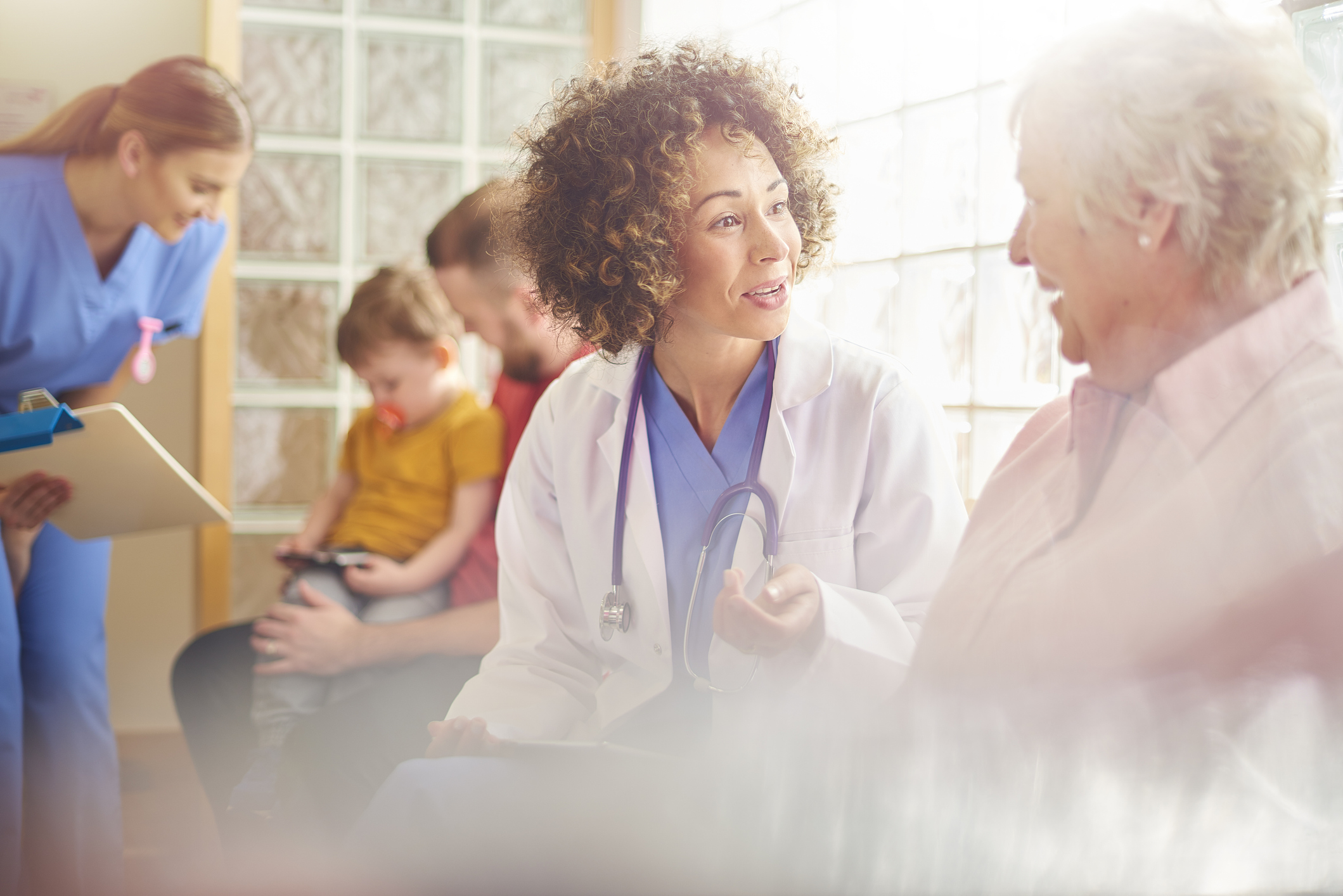 Doctor talking with elderly patient in waiting room