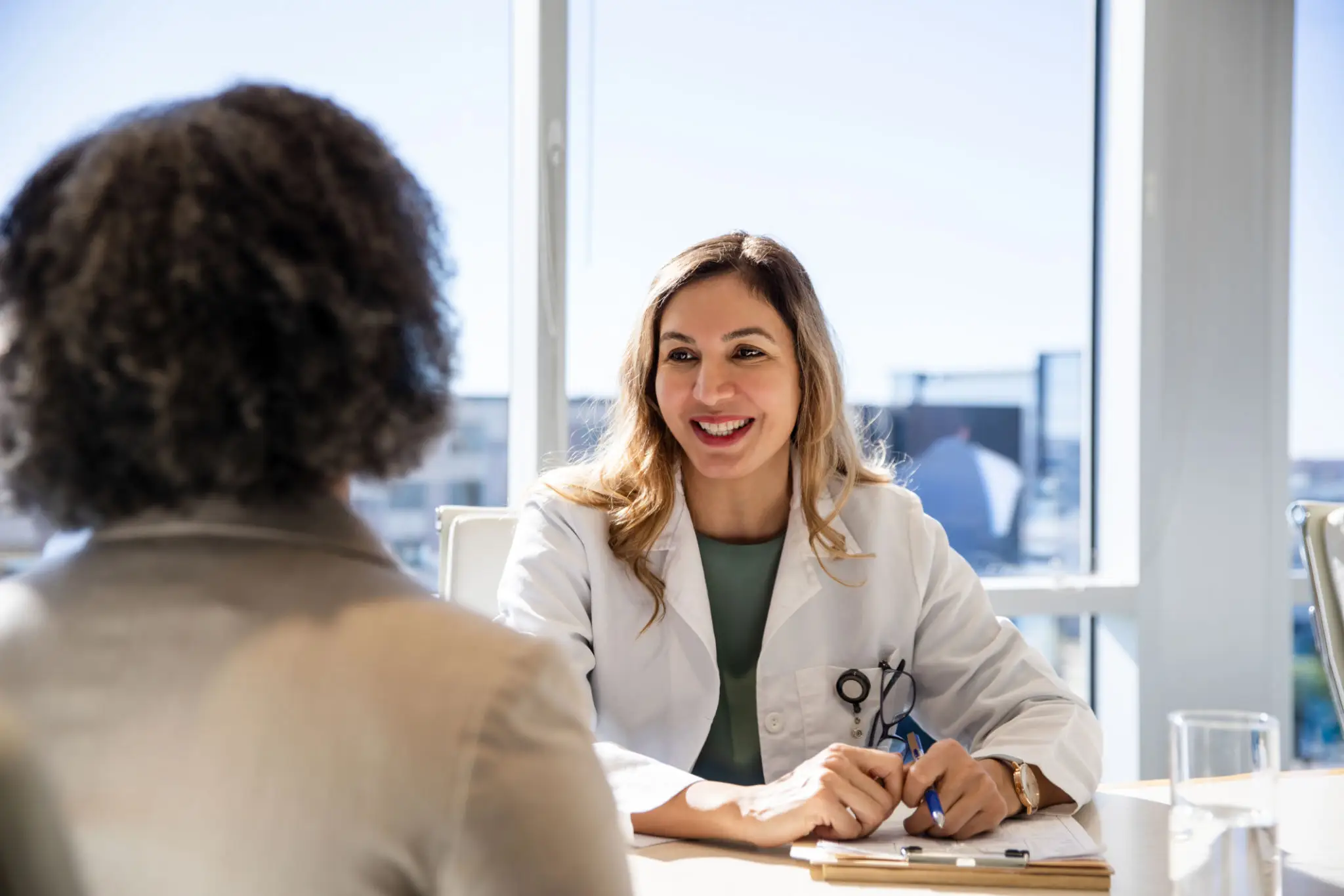 Smiling doctor consulting with patient