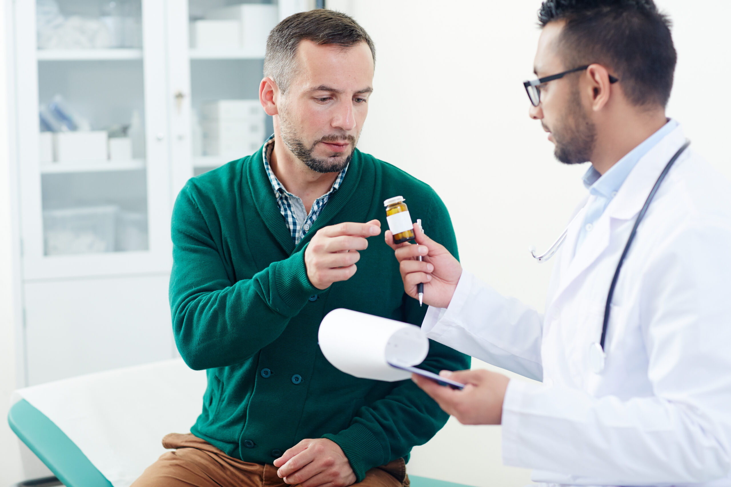 Doctor showing medication bottle to patient