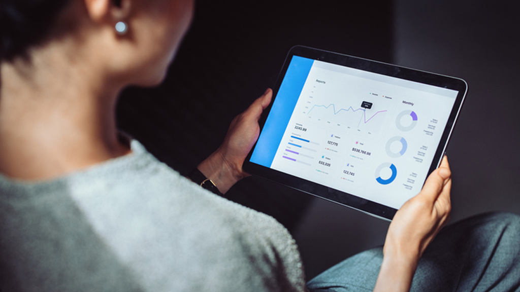 Person viewing tablet with charts and graphs