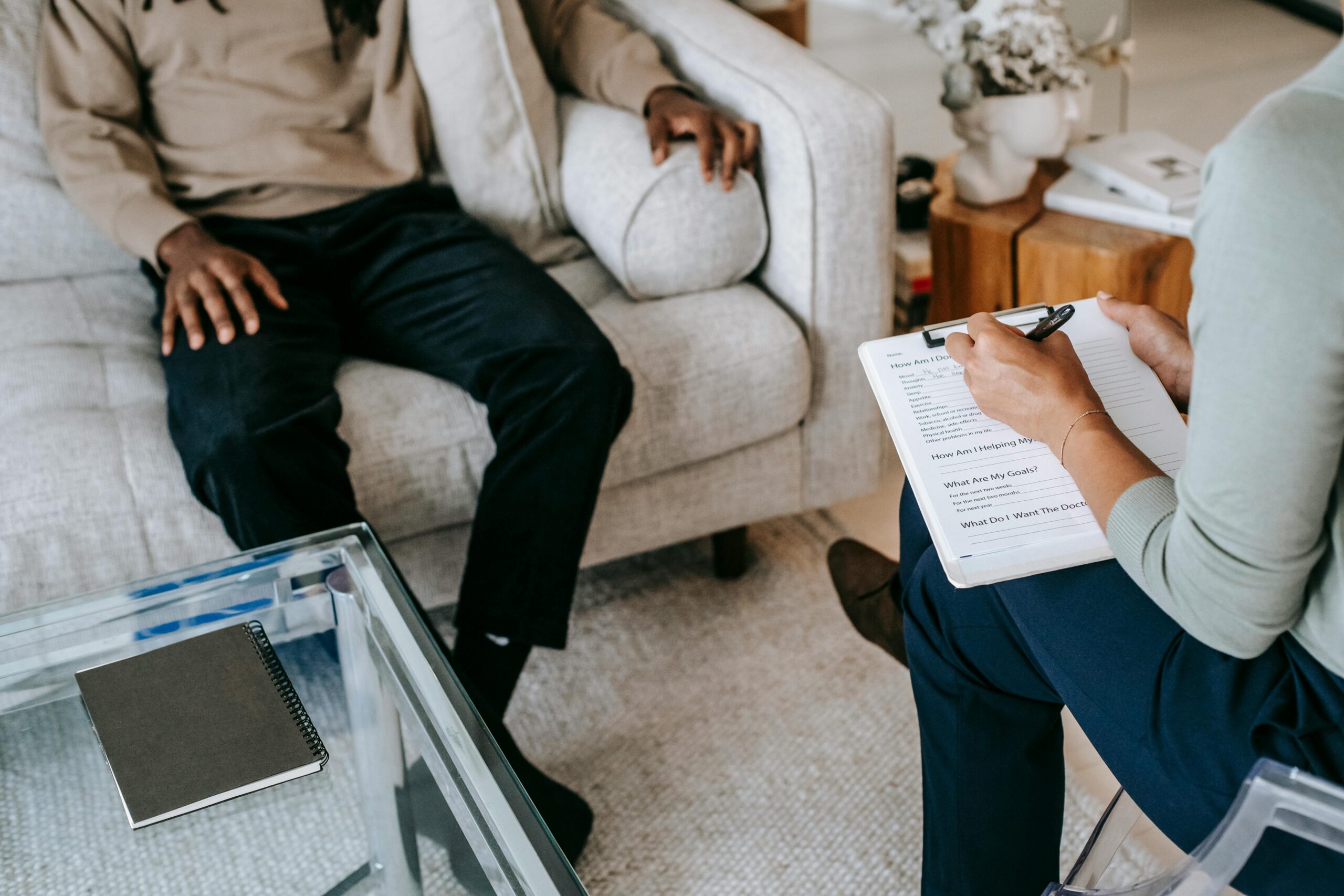 Therapist taking notes with client on couch