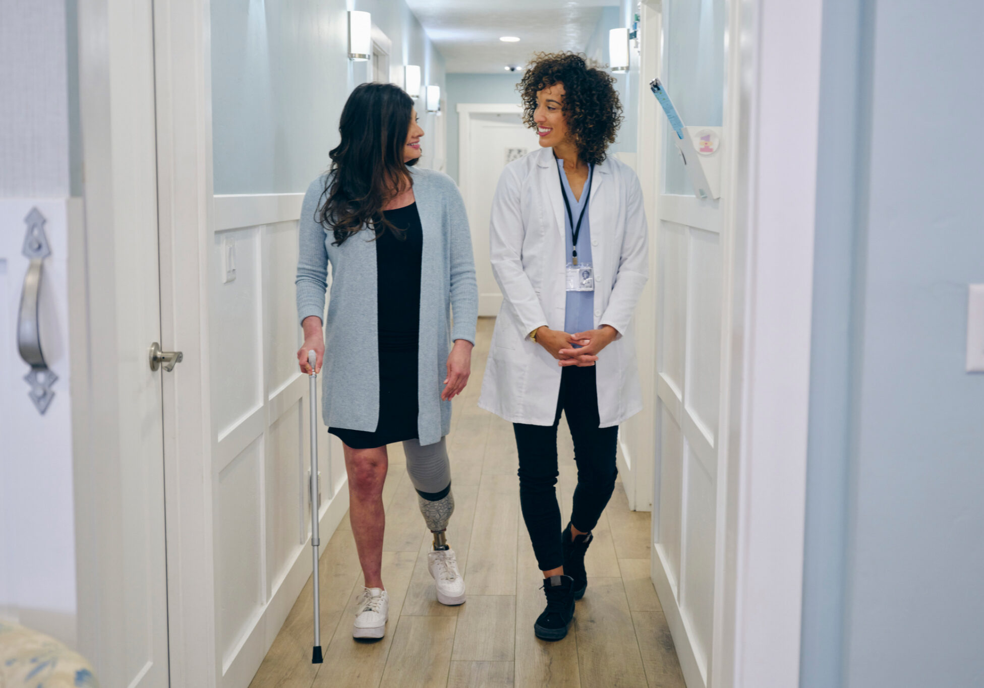 Woman with prosthetic leg walking with doctor