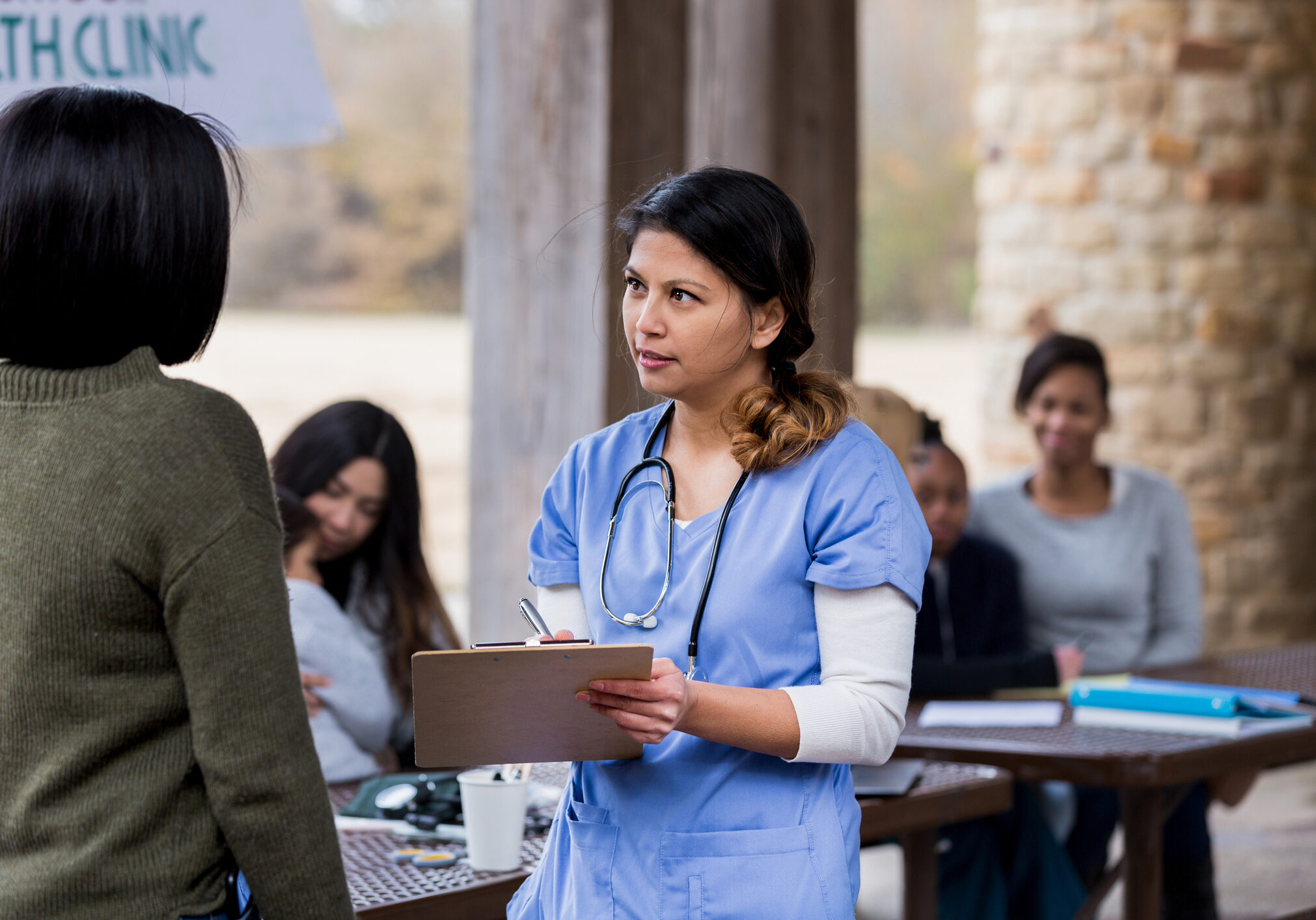 Nurse consulting patient at outdoor health clinic