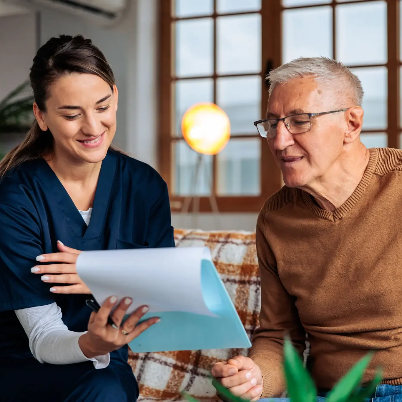 Caregiver reviewing documents with elderly man